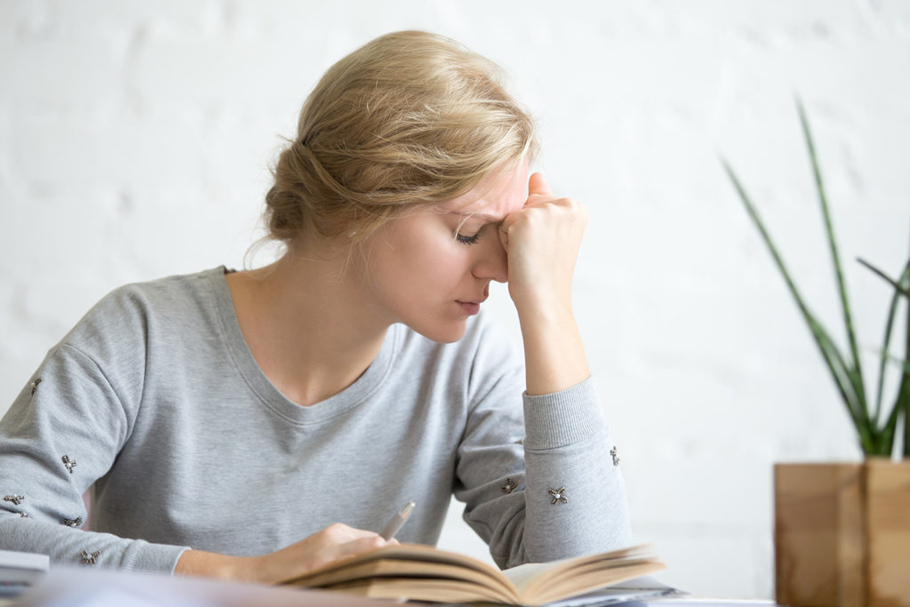 woman suffering from vertigo while reading