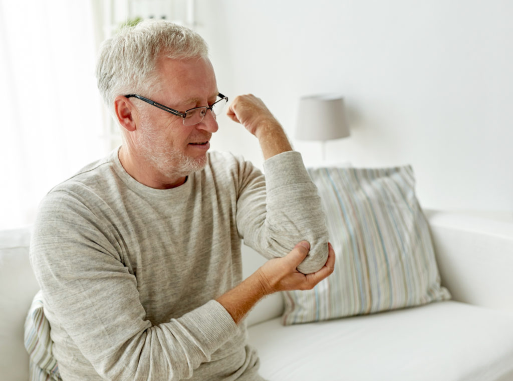 old man suffering from elbow pain