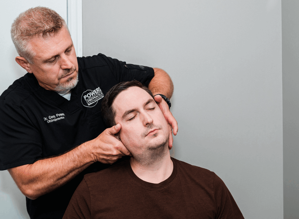 Dr Cory Powers giving the patient a neck pain treament